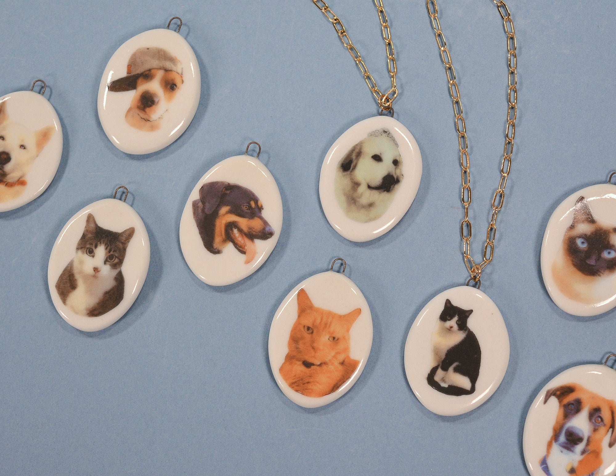 Necklaces with oval pendants featuring images of dogs and cats on a blue background