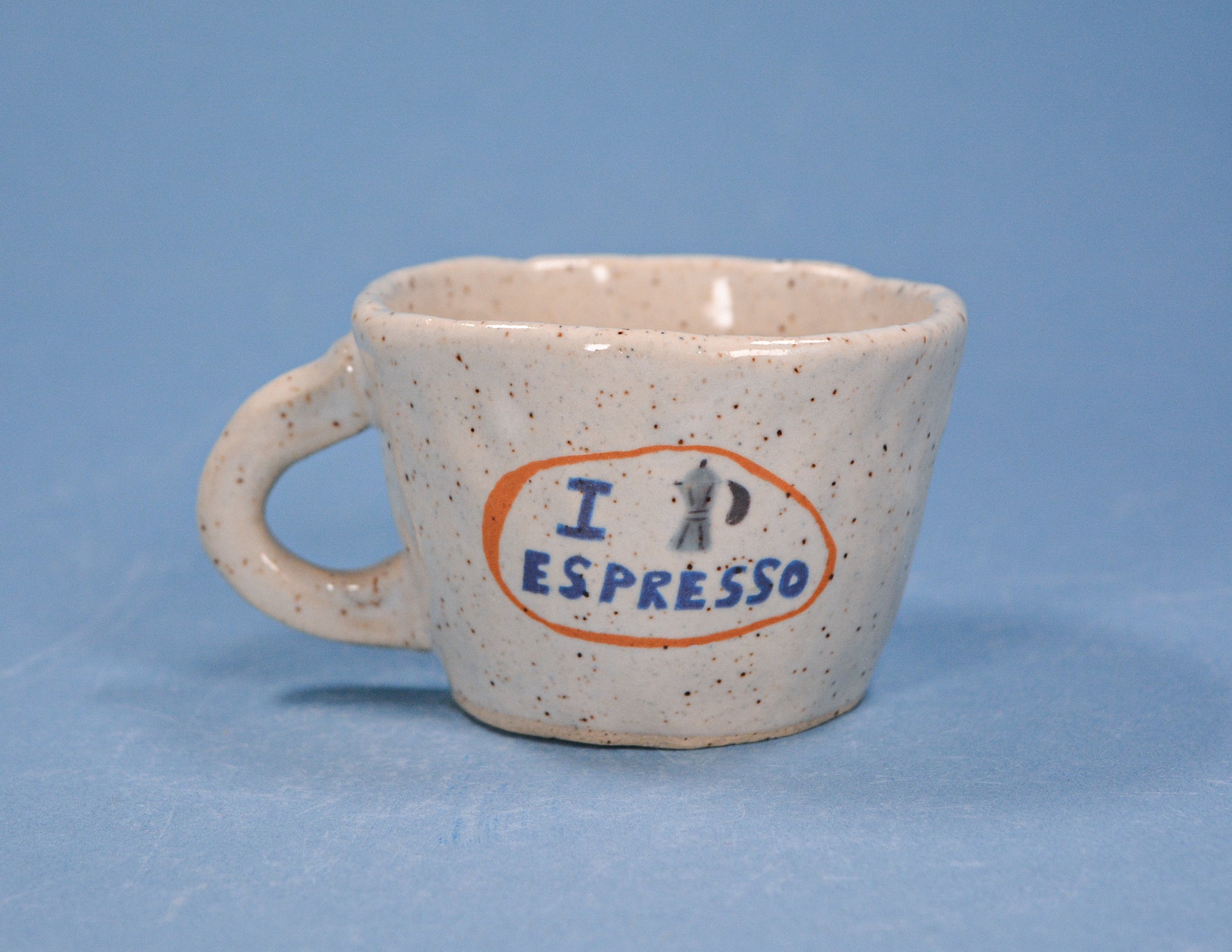 A Speckled Stoneware Espresso cup with a I Love Ceramics design but instead of a heart it is a moka pot 