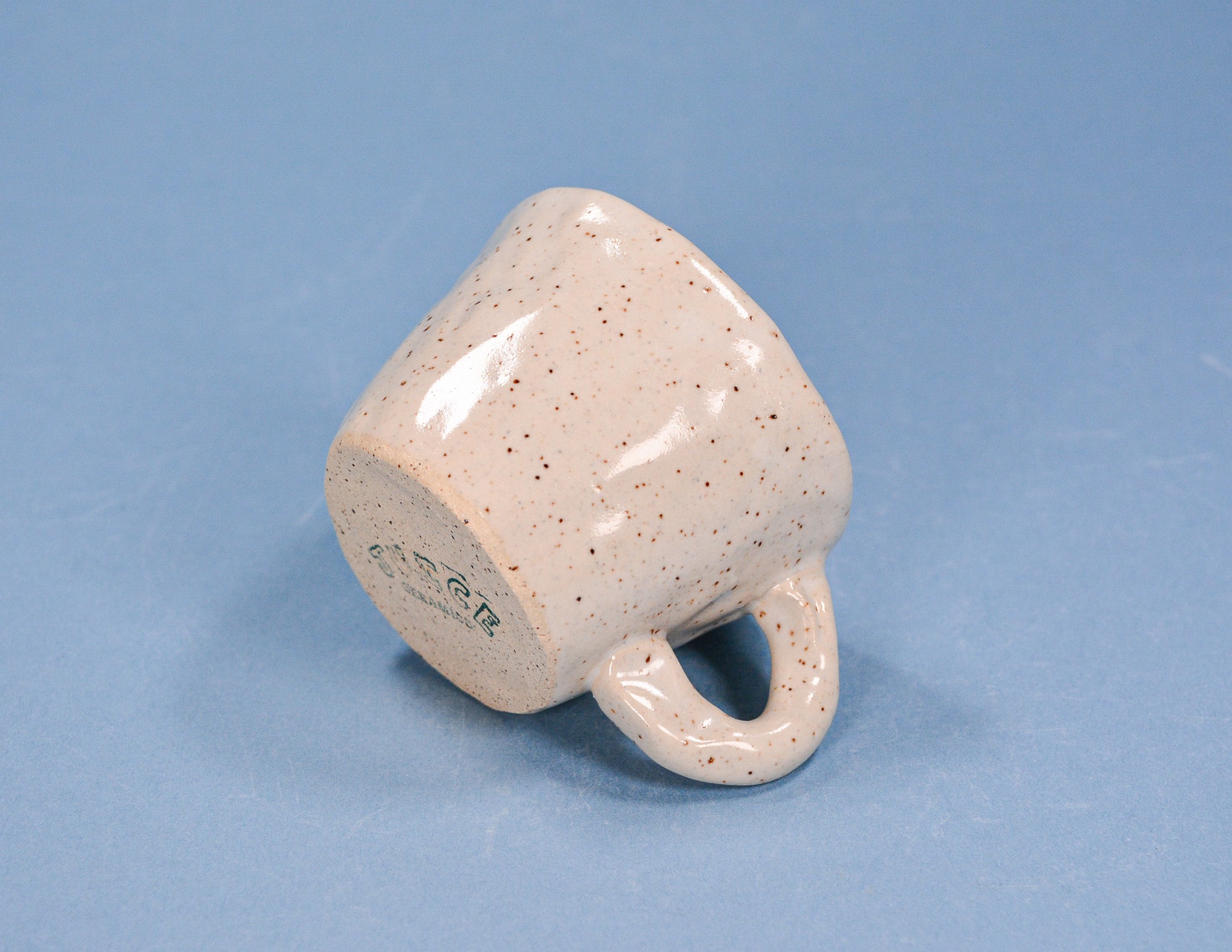 Speckled ceramic mug on a blue background
