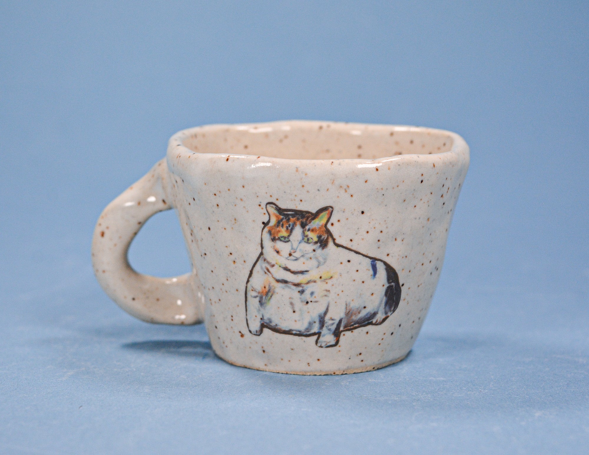 Ceramic mug with a cat illustration on a blue background